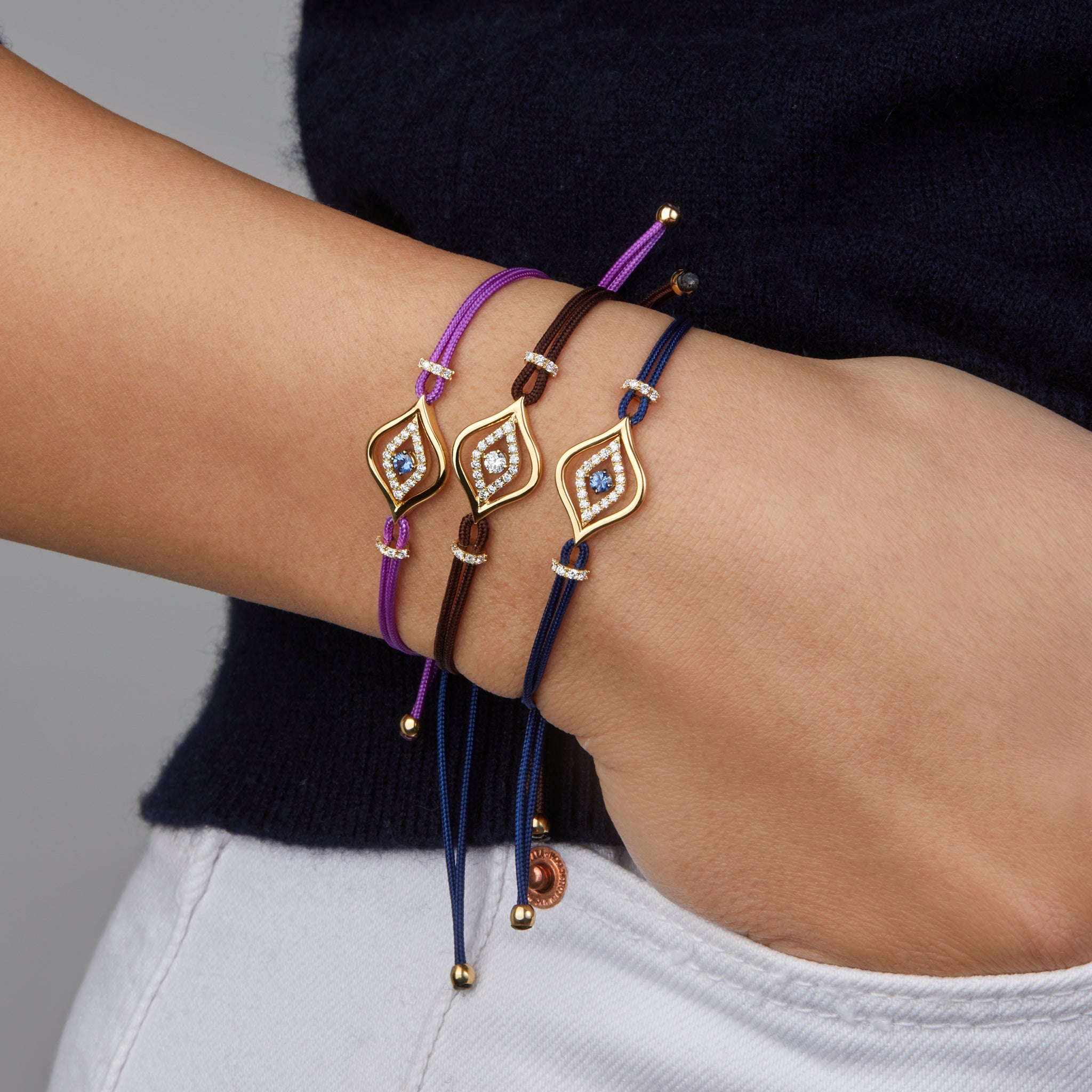 Evil eye cord bracelets portrayed on hand model.