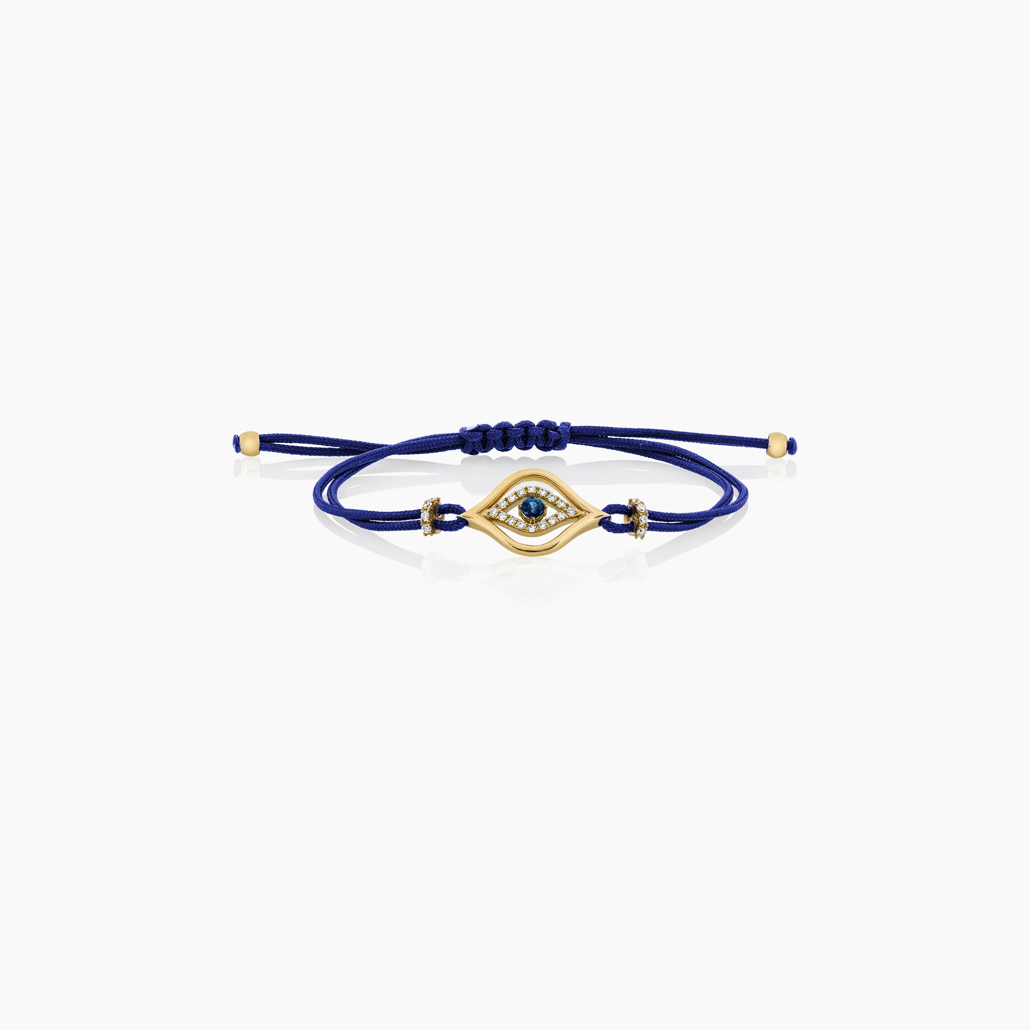 A stylish evil eye cord bracelet featuring a central sapphire surrounded by diamonds, set on a cord, presented against an off-white background.