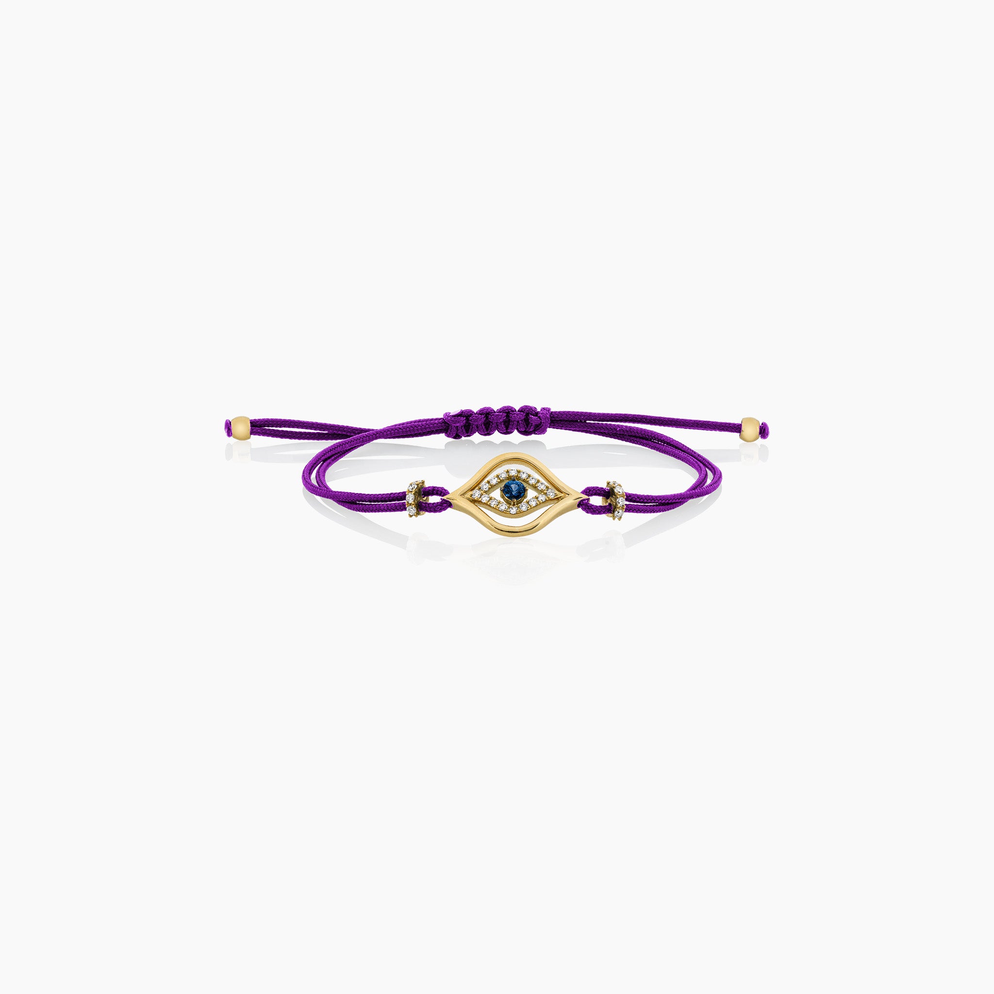 A stylish evil eye cord bracelet featuring a central sapphire surrounded by diamonds, set on a cord, presented against an off-white background.
