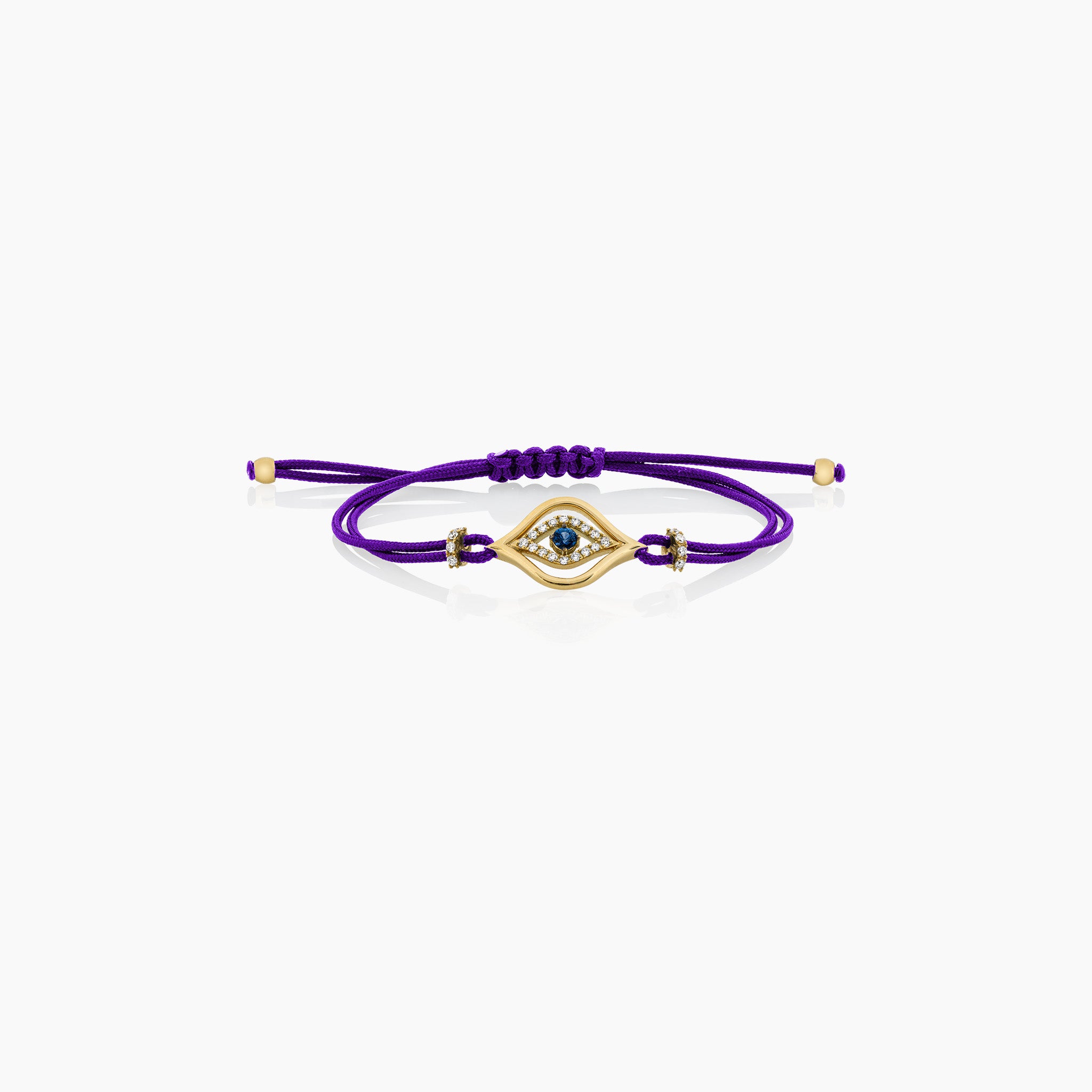 A stylish evil eye cord bracelet featuring a central sapphire surrounded by diamonds, set on a cord, presented against an off-white background.