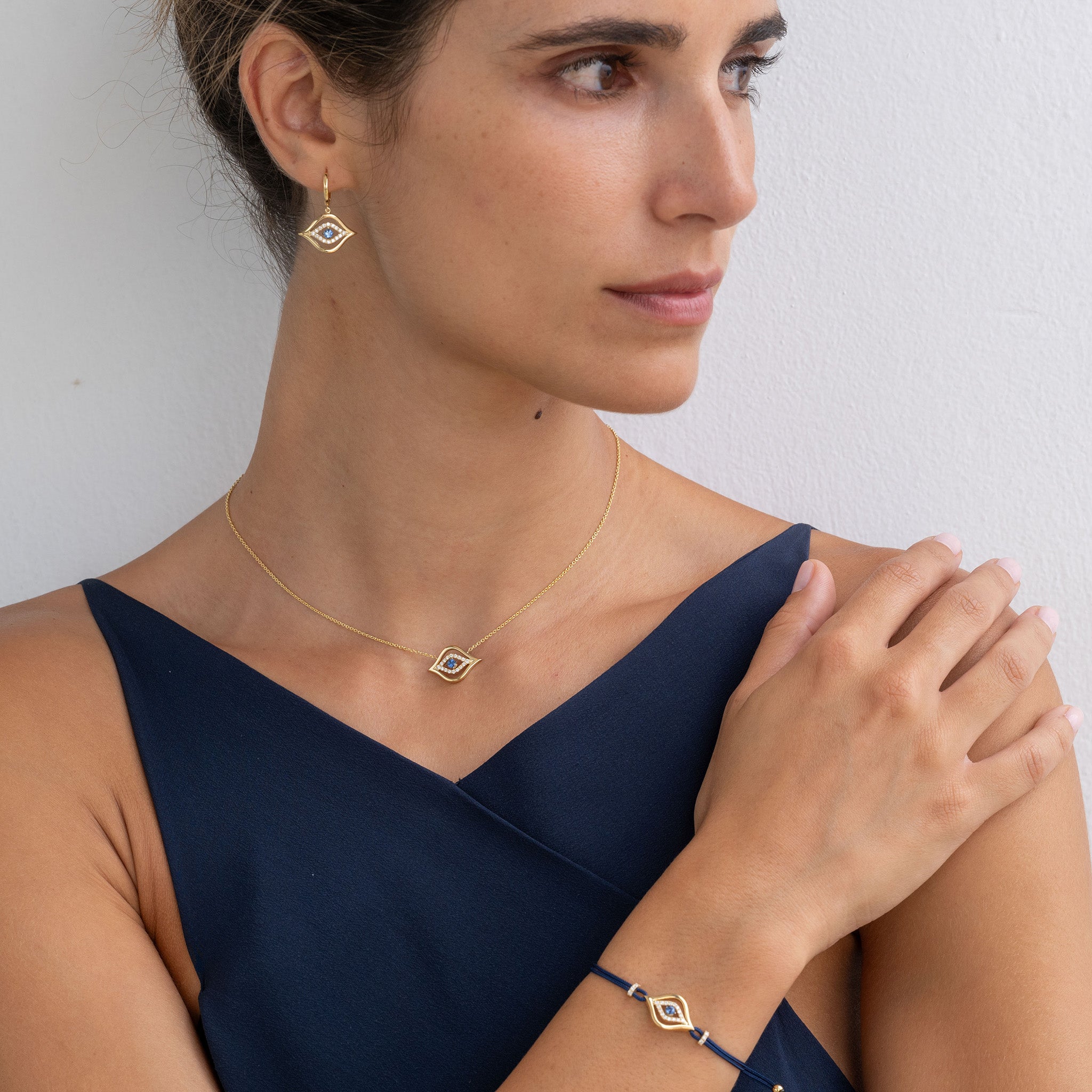 Model adorned with an enchanting Evil Eye necklace, earrings, and bracelet jewellery set.