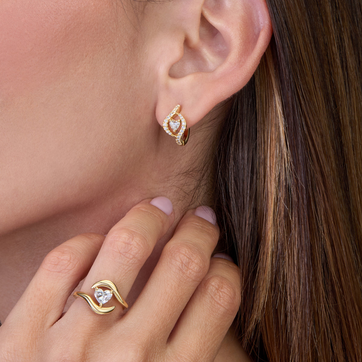 Gold Heart earrings and ring with diamond displayed on a model