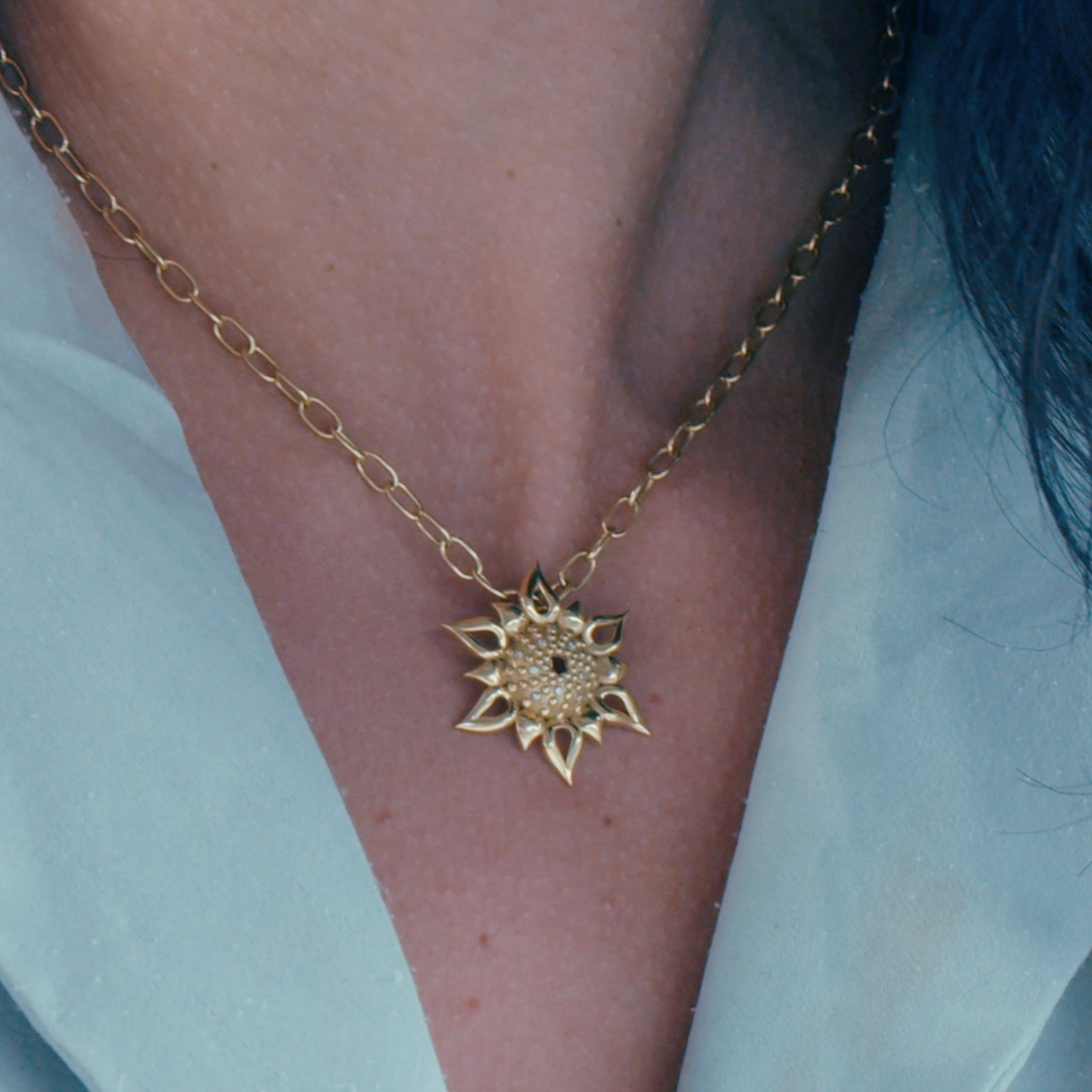 yellow gold necklace charm displayed on neck