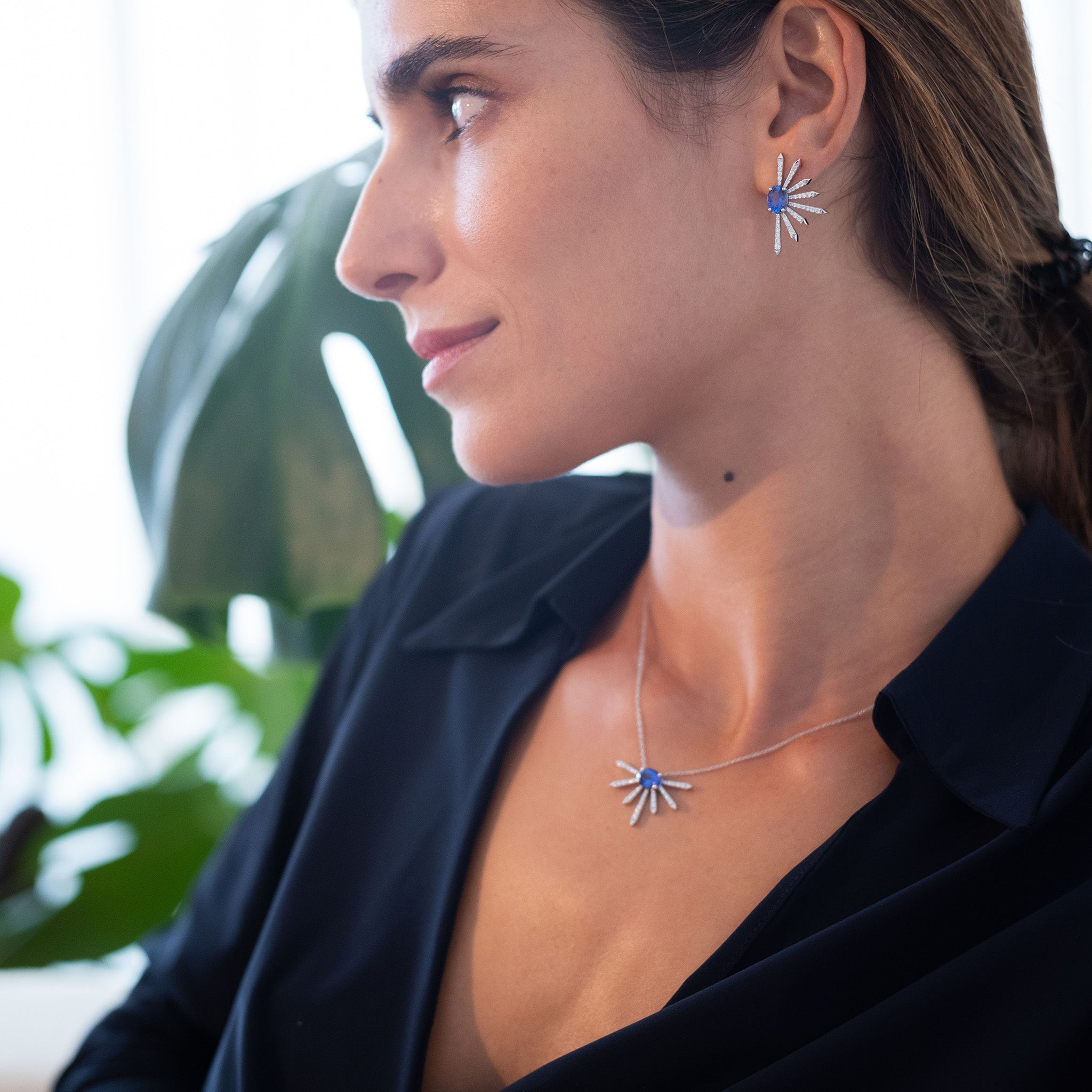 Diamond earrings with two elegant tanzanite ovals and pendant depicted on a model.