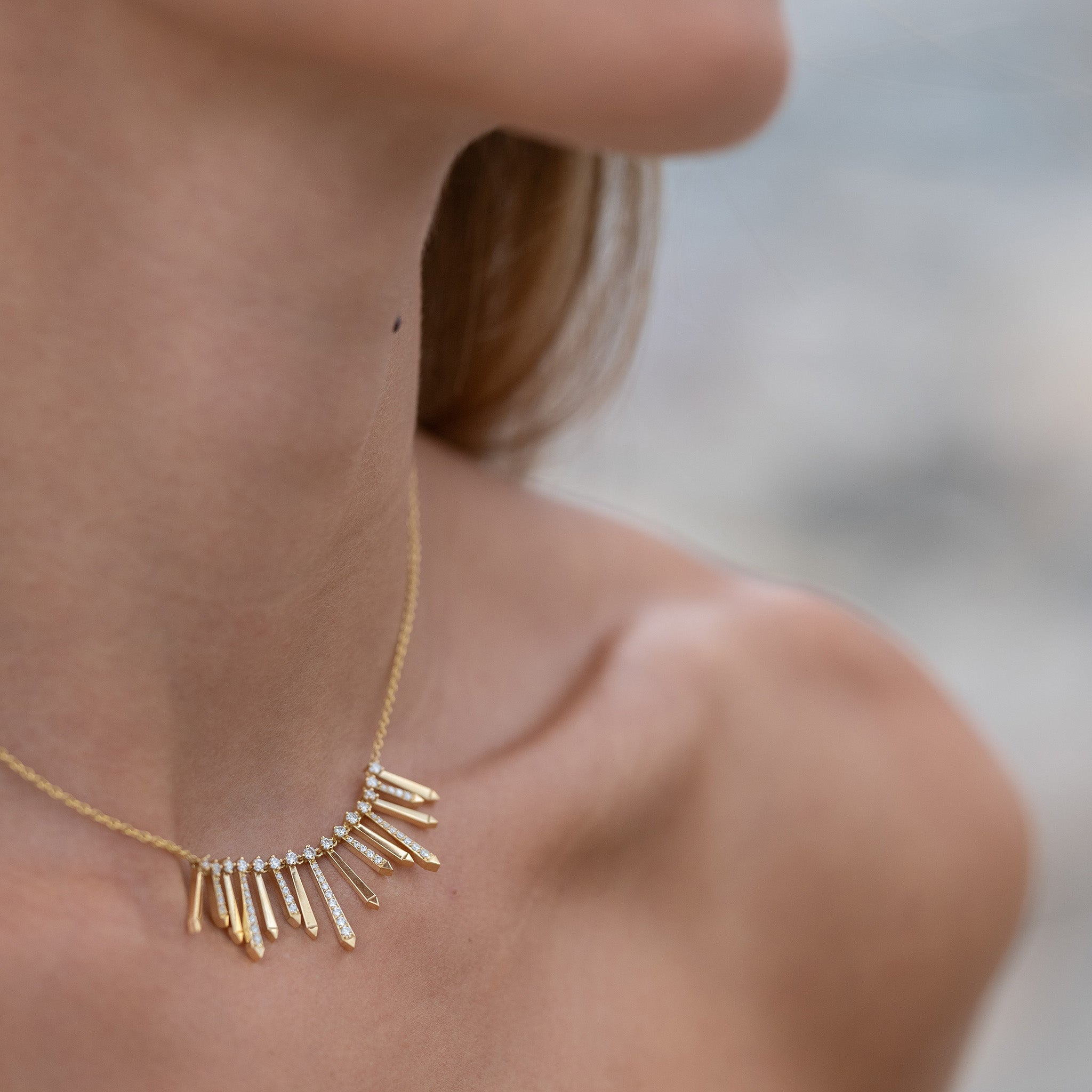 A radiant and sophisticated necklace crafted in gleaming yellow gold, adorned with dazzling diamonds, presented on model.
