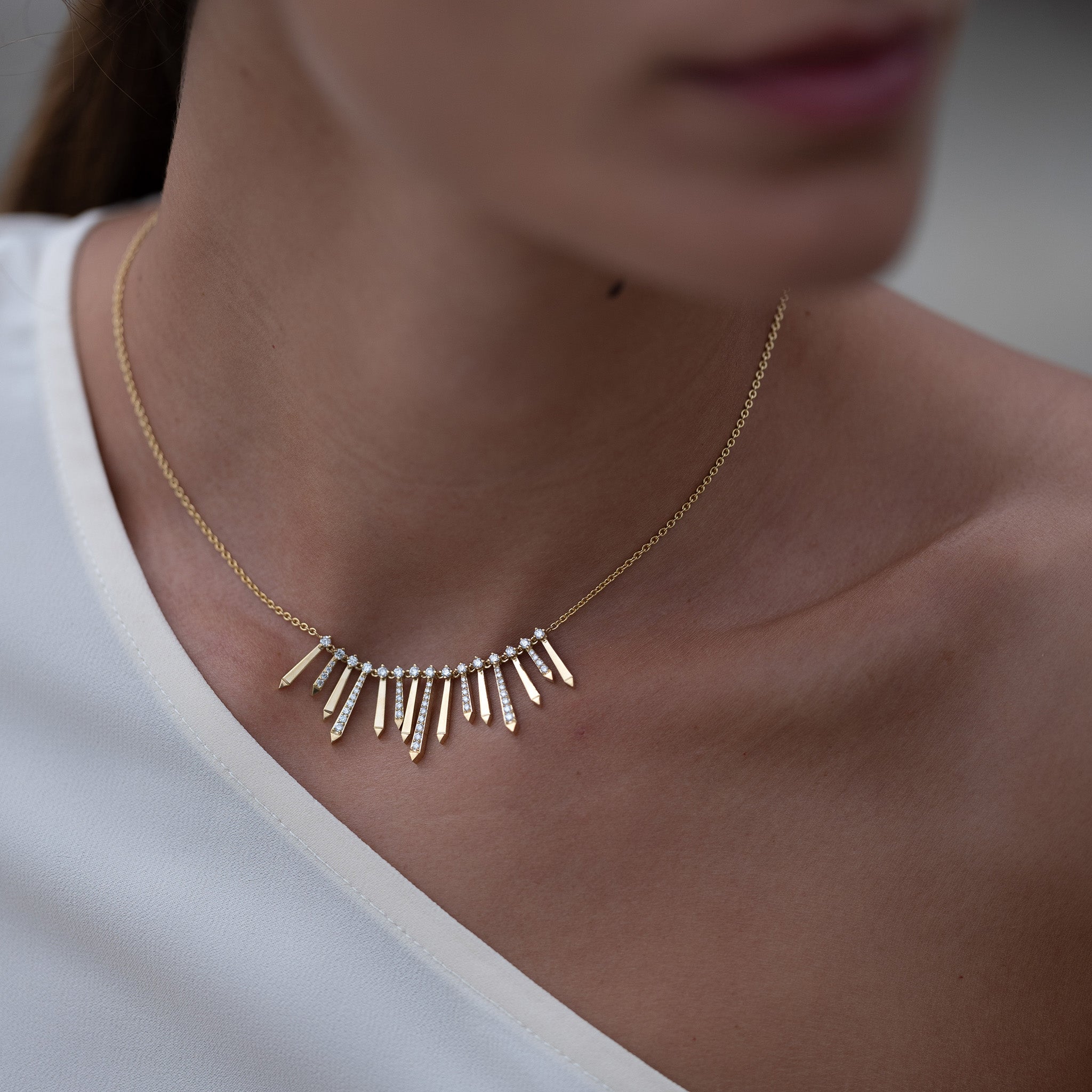 A radiant and sophisticated necklace crafted in gleaming yellow gold, adorned with dazzling diamonds, presented on model.