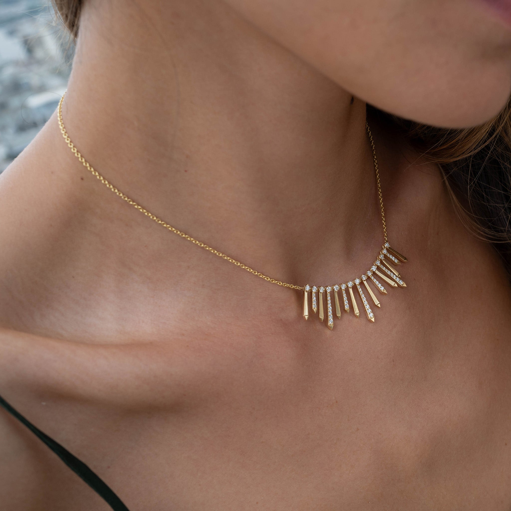 A radiant and sophisticated necklace crafted in gleaming yellow gold, adorned with dazzling diamonds, presented on model.