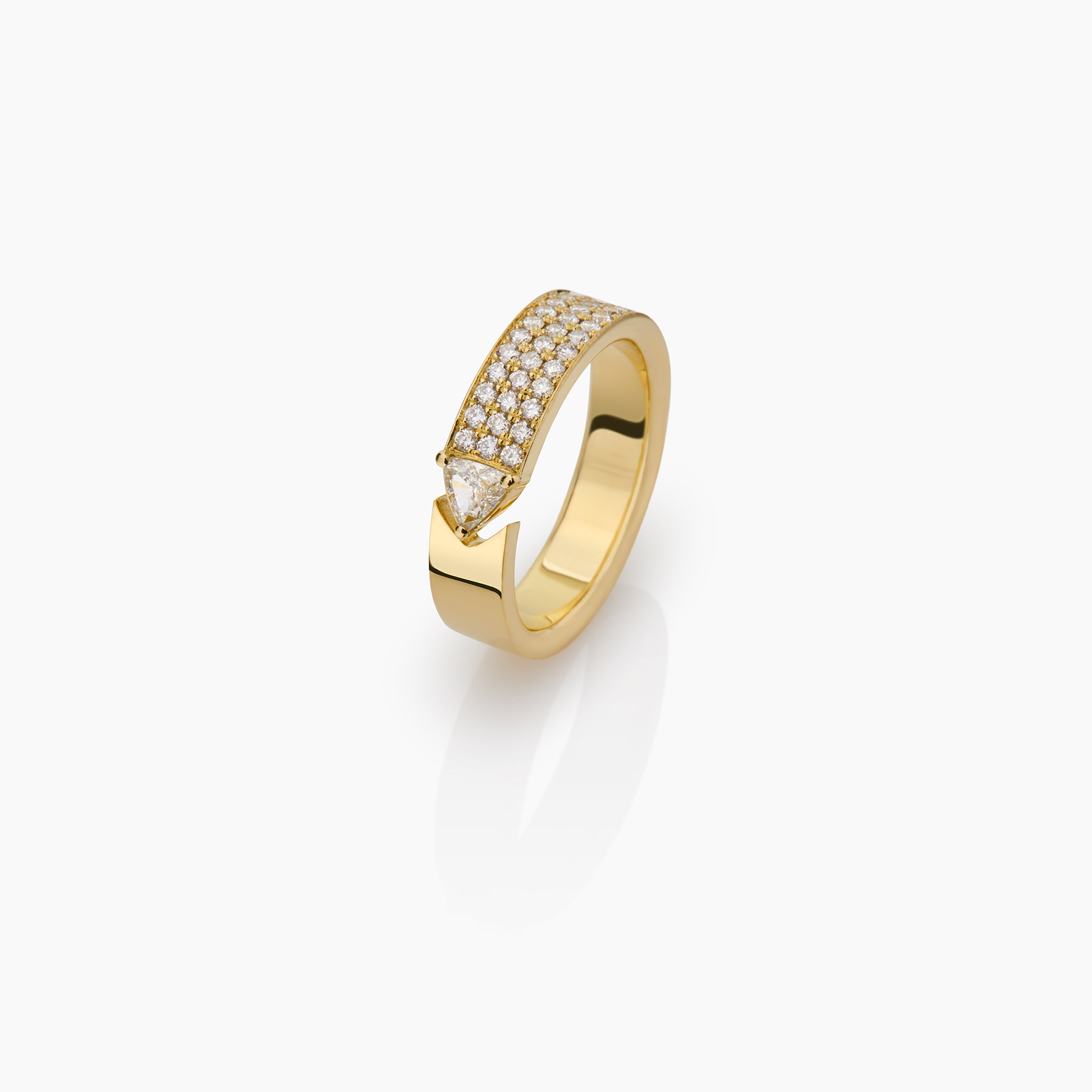 yellow gold ring with round brilliant diamonds and trillion displayed against an off white background.