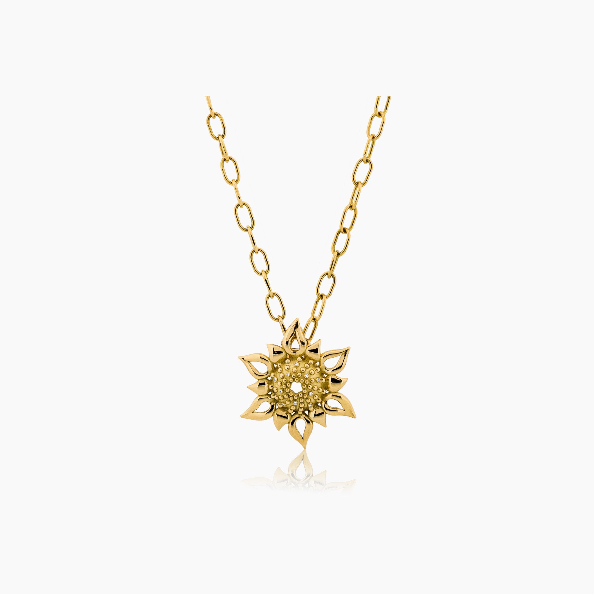 Apollo Echinus Necklace: A radiant pendant with intricate sea urchin-inspired design and sunburst motif on an off-white background.
