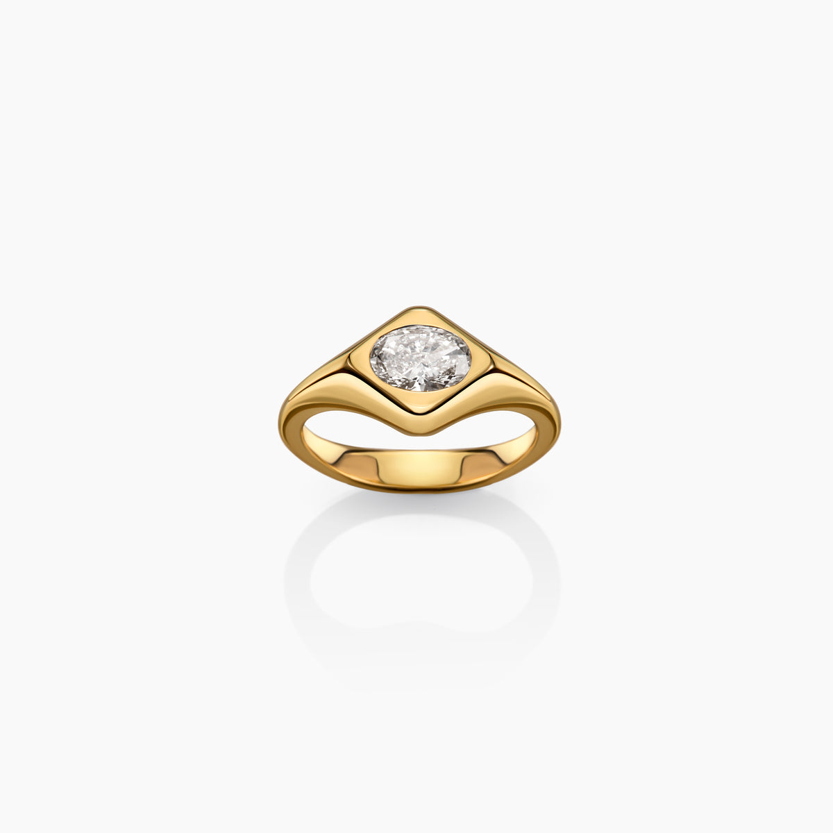 A yellow gold ring with a oval diamond shown on a clean white background with a soft reflection below.