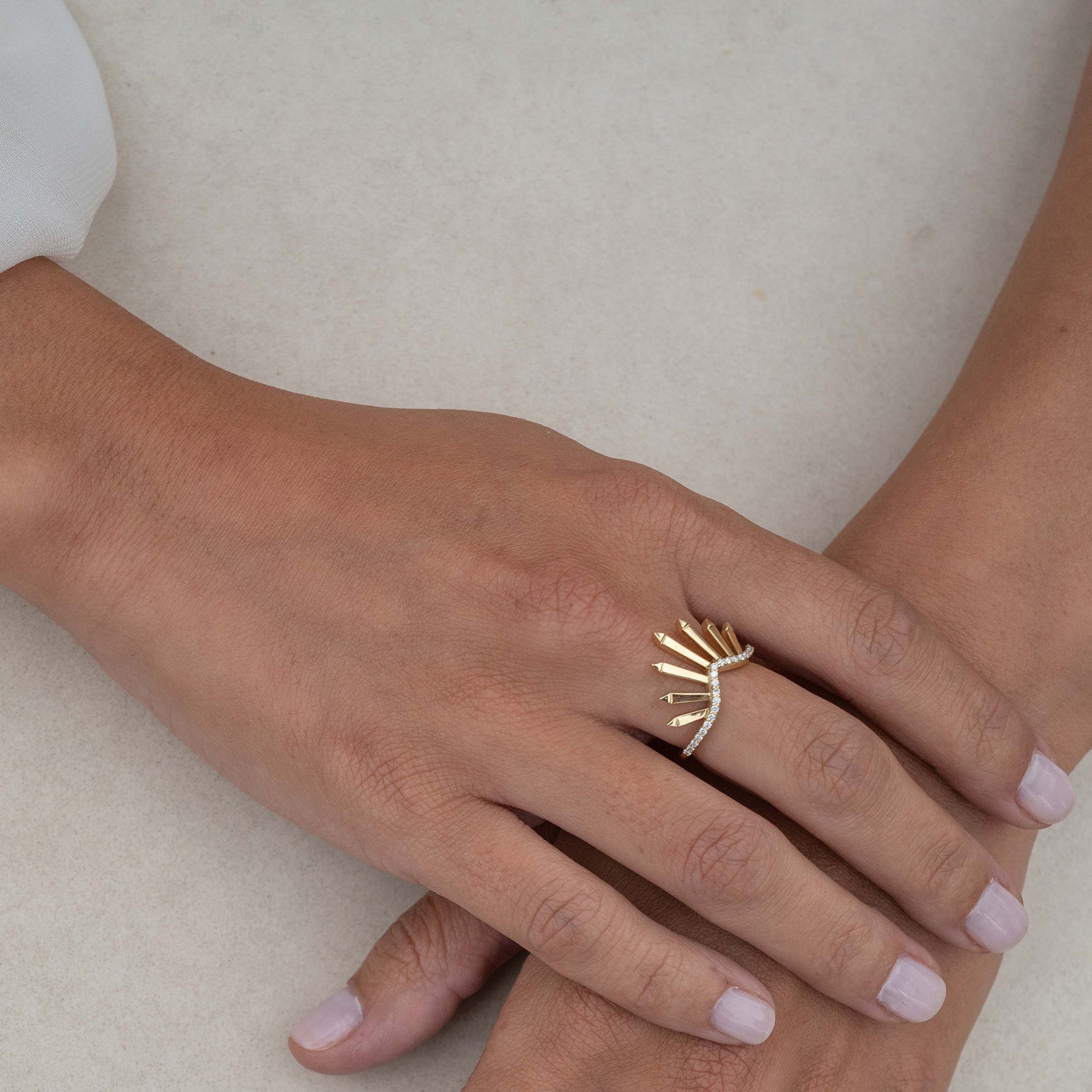 Yellow Gold Ring: Featuring radiant sunburst motifs adorned with diamonds, showcased on hand model.