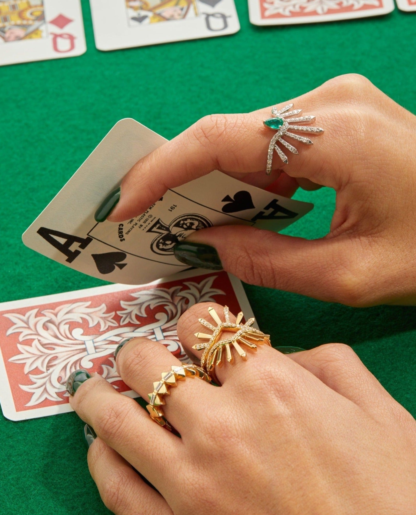 Rings displayed on hand model playing cards. 