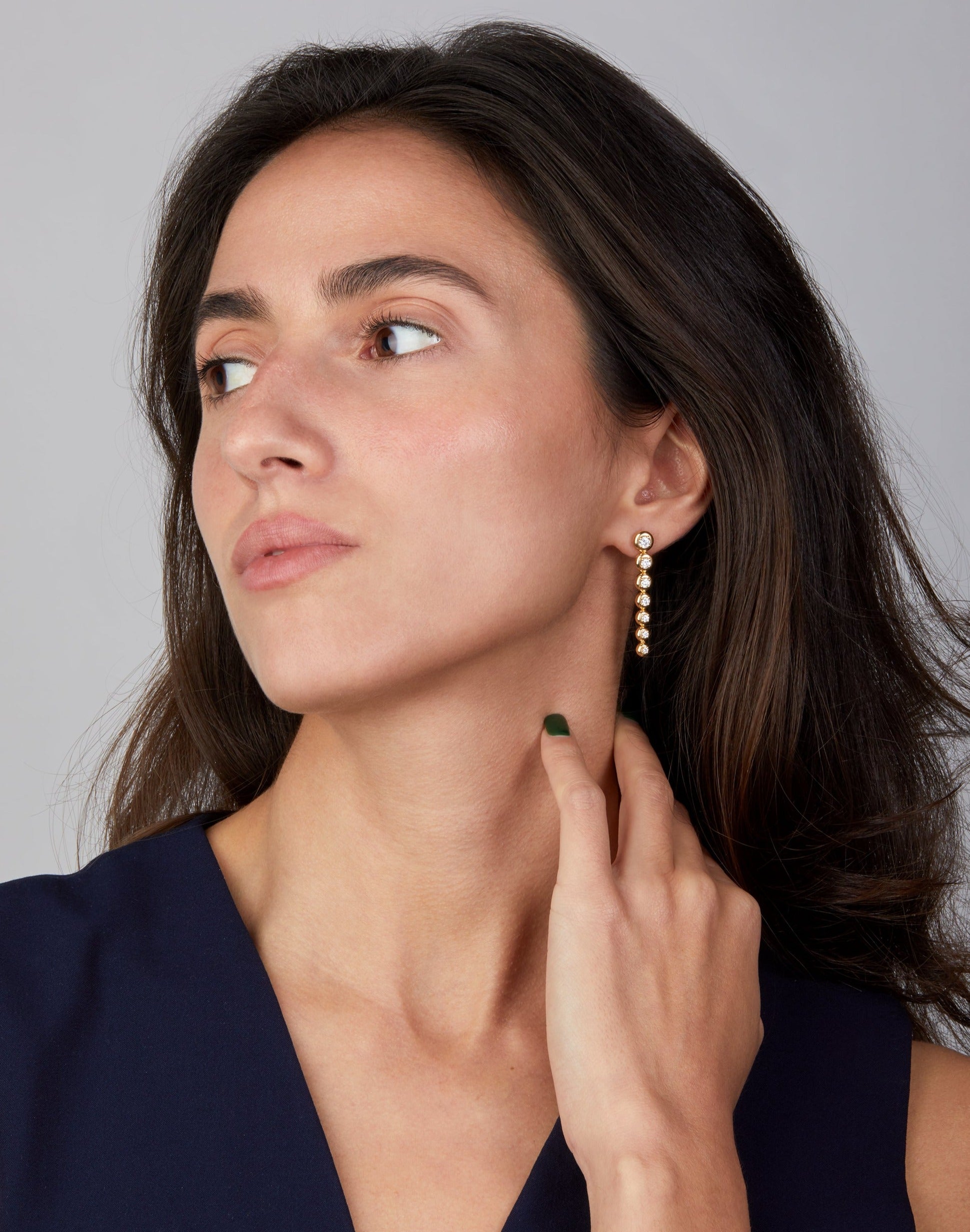 Star trail yellow gold earrings with diamonds displayed on model.