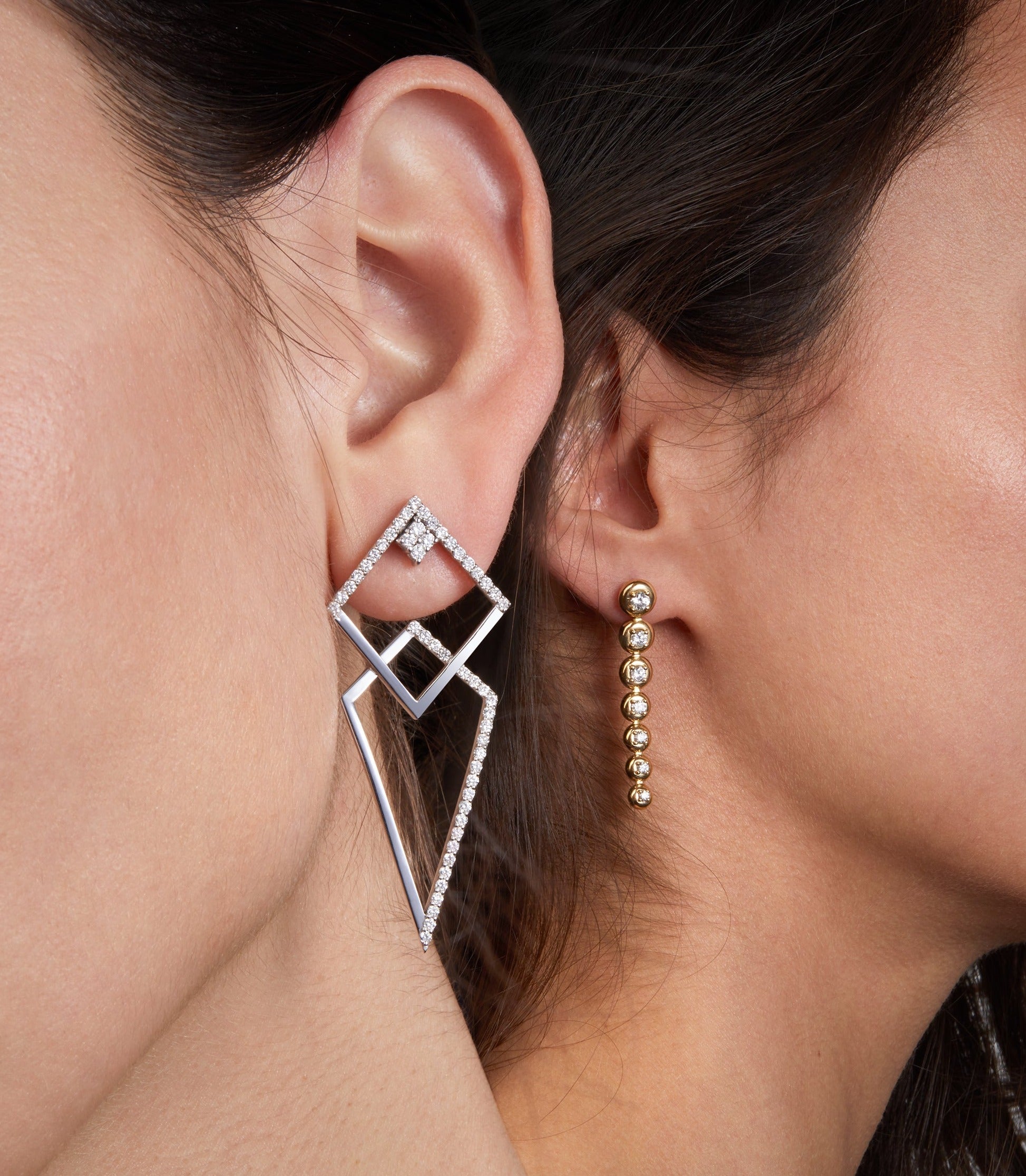 two different earrings displayed on two different models that can be combined in one design . 
