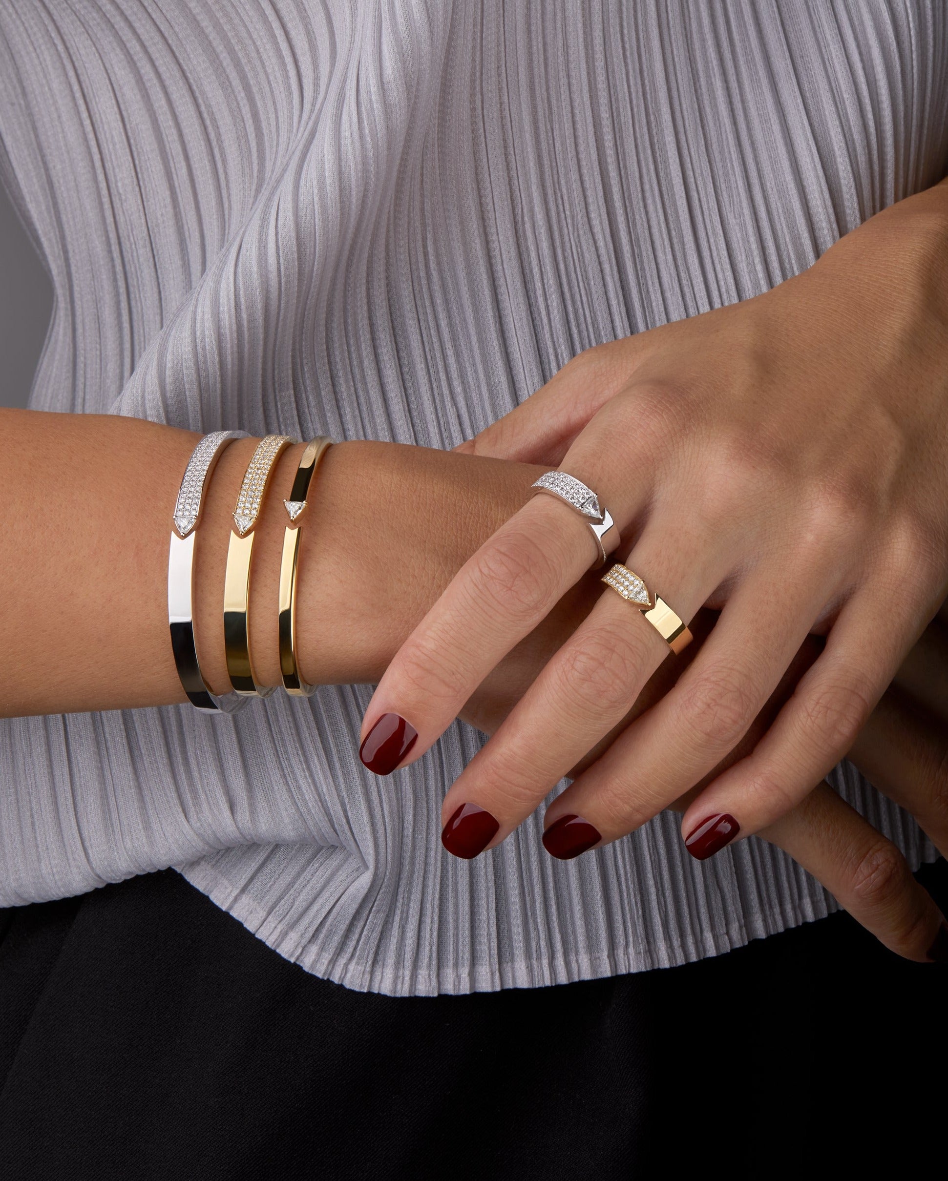 Bangles and rings displayed on hand model. 