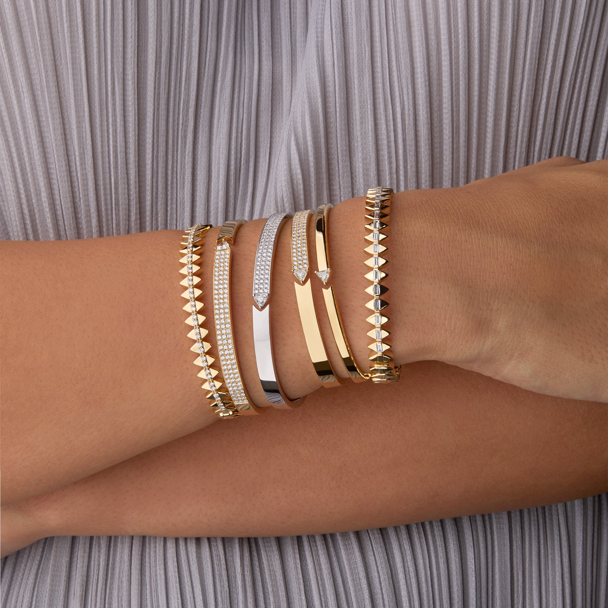 Stack of solidarity and stellar standstill bangles portrayed on hand model. 