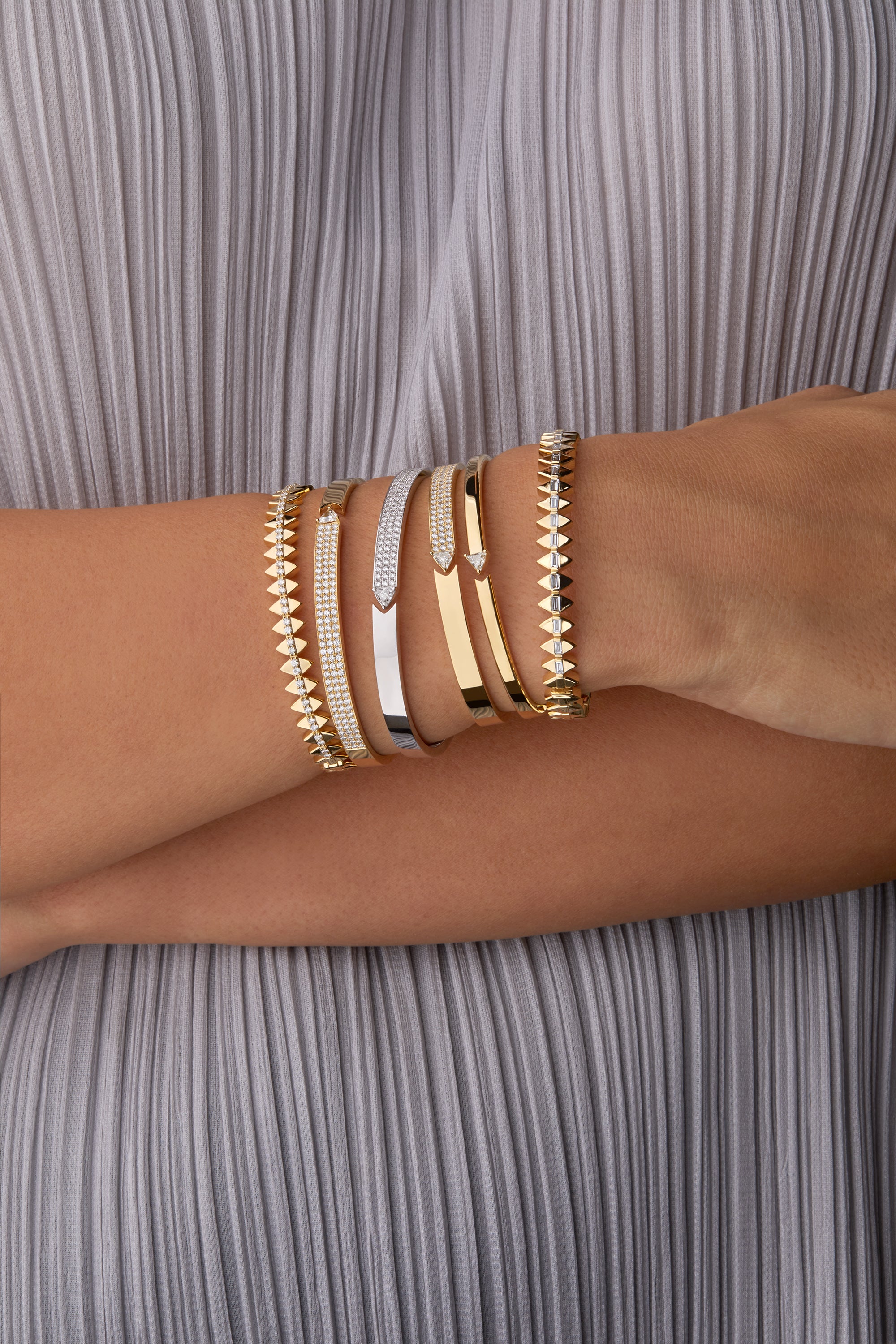 Stack of solidarity and stellar standstill bangles portrayed on hand model. 