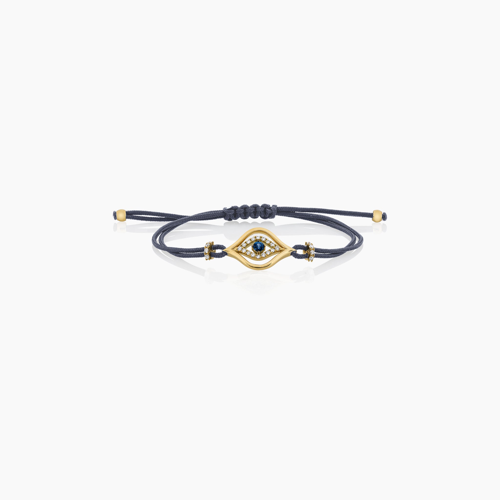 A stylish evil eye cord bracelet featuring a central sapphire surrounded by diamonds, set on a cord, presented against an off-white background. 