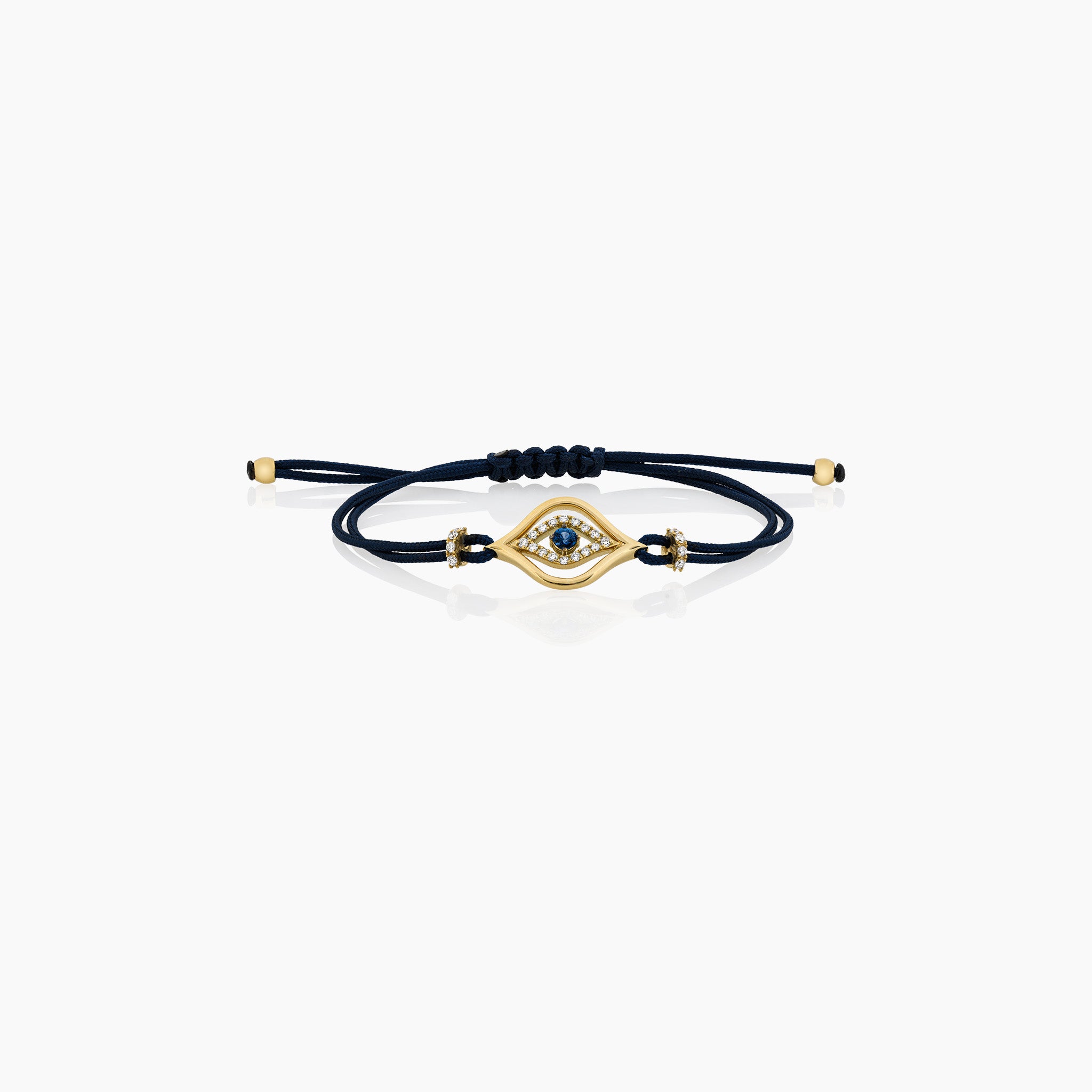 A stylish evil eye cord bracelet featuring a central sapphire surrounded by diamonds, set on a cord, presented against an off-white background. 