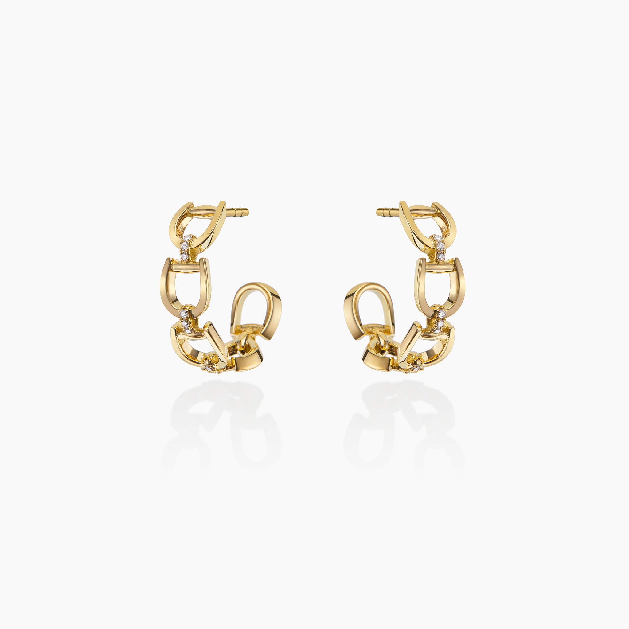 Fulanda Everyday Horsebit Earrings in yellow gold displayed on an off white background.