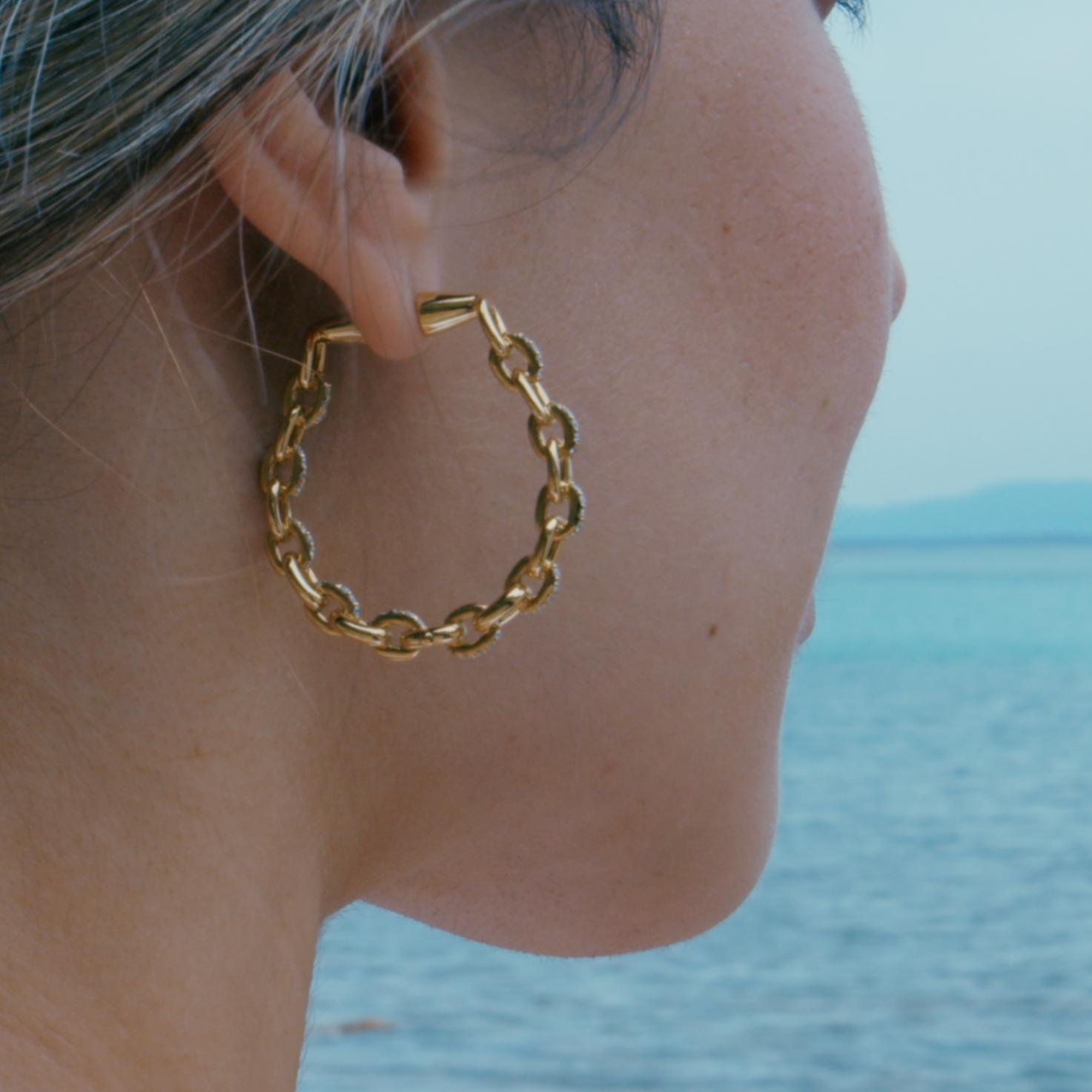 Horsebit Diamond link Hoop Earrings in yellow gold displayed on model