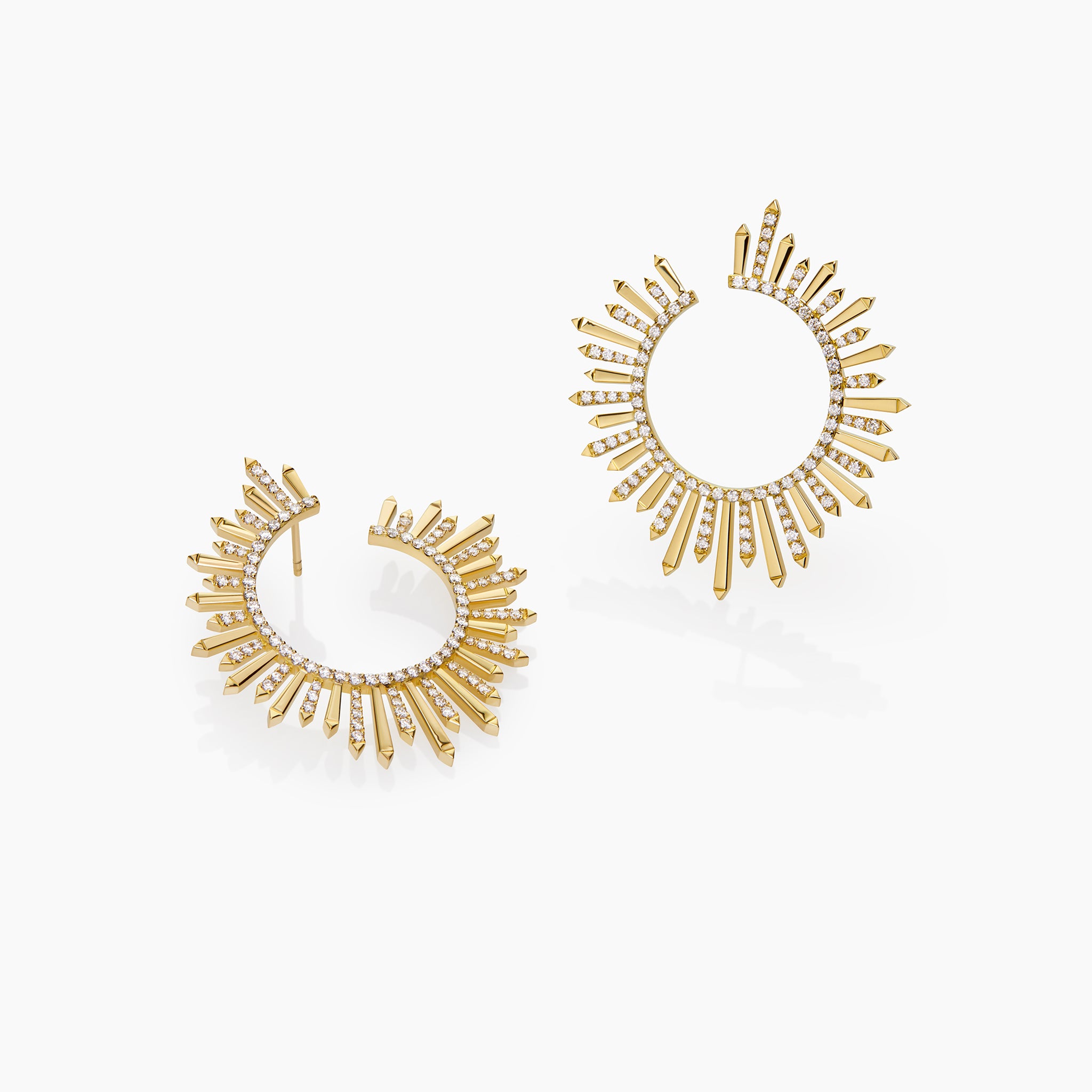 Yellow gold and diamond Polaris earrings on an off-white background.
