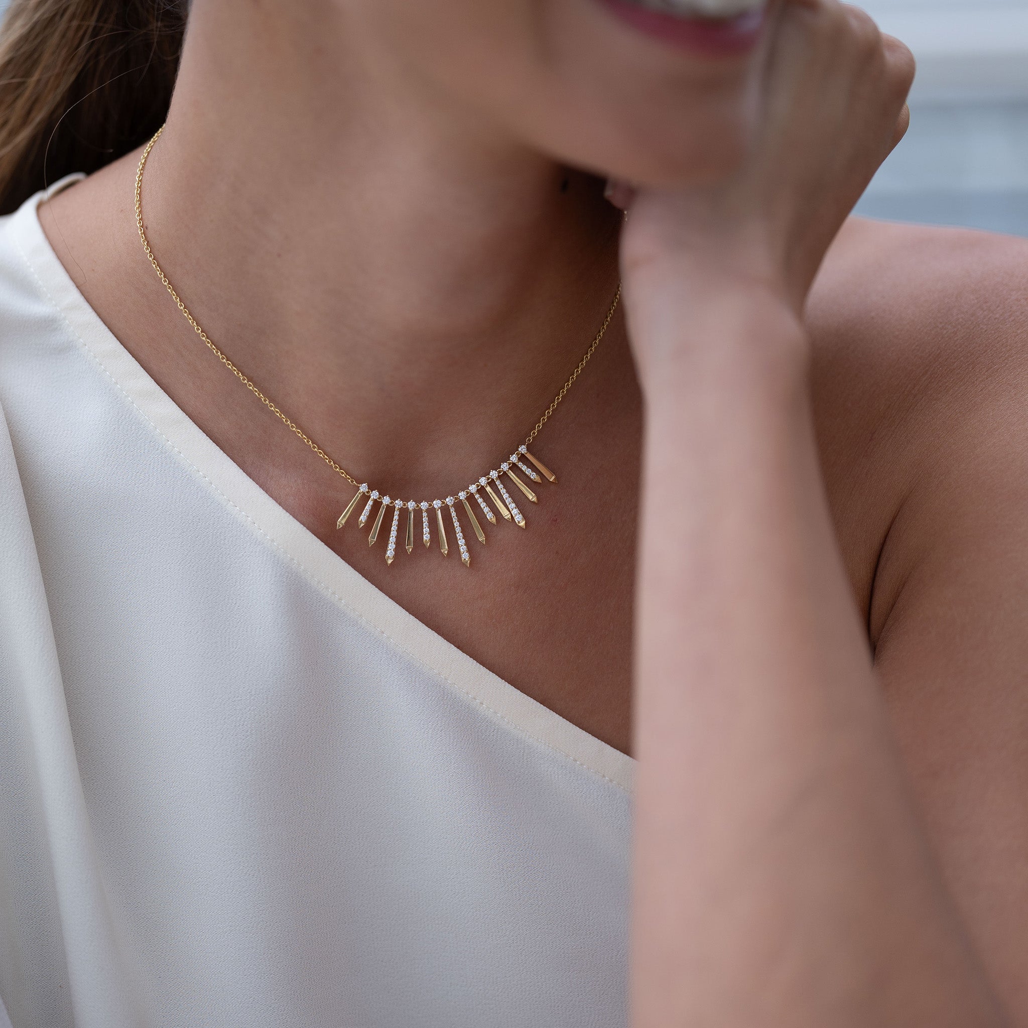 A radiant and sophisticated necklace crafted in gleaming yellow gold, adorned with dazzling diamonds, presented on model.