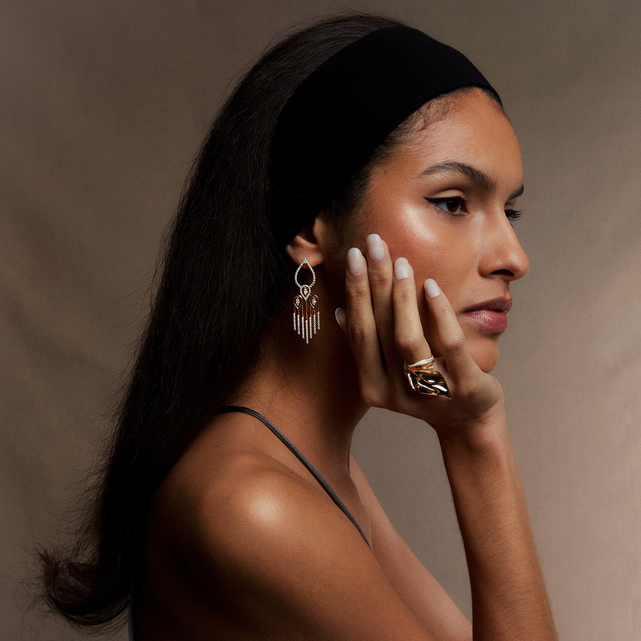 Sahara yellow gold earrings adorned with white diamonds, displayed on model.