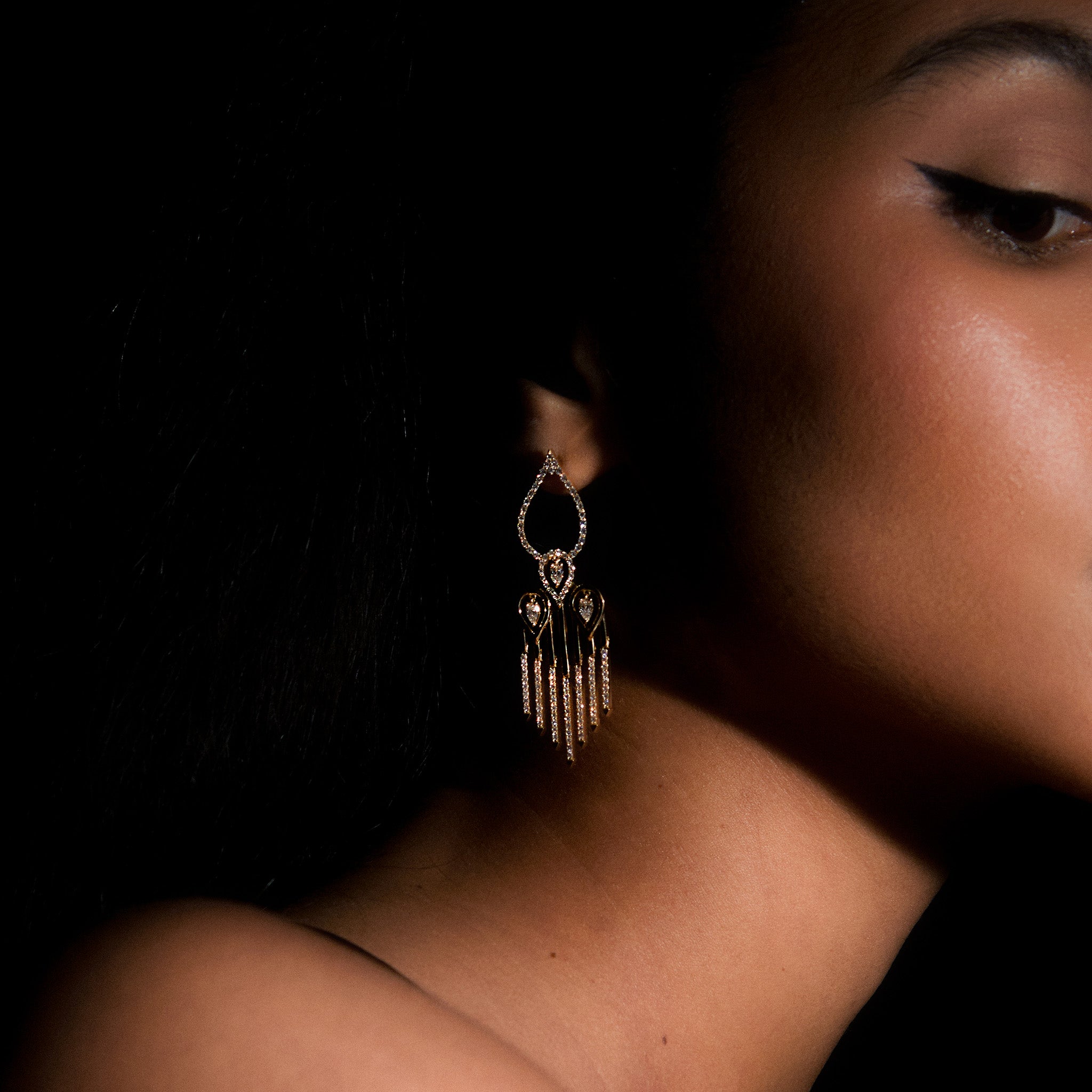Sahara yellow gold earrings adorned with white diamonds, displayed on model 