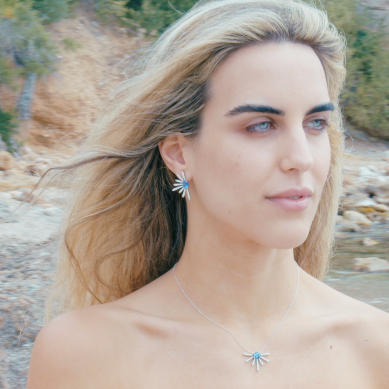 Diamond earrings with two elegant tanzanite ovals, depicted on a model. 