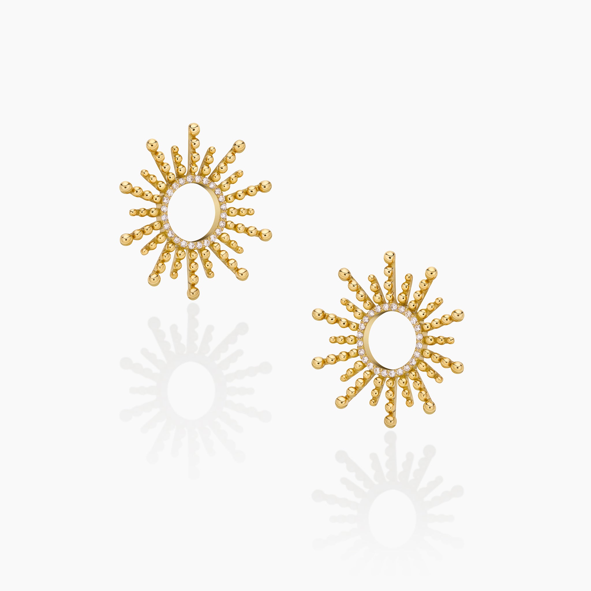 Sea urchin-inspired yellow gold earrings with diamonds, showcased on an off-white background.