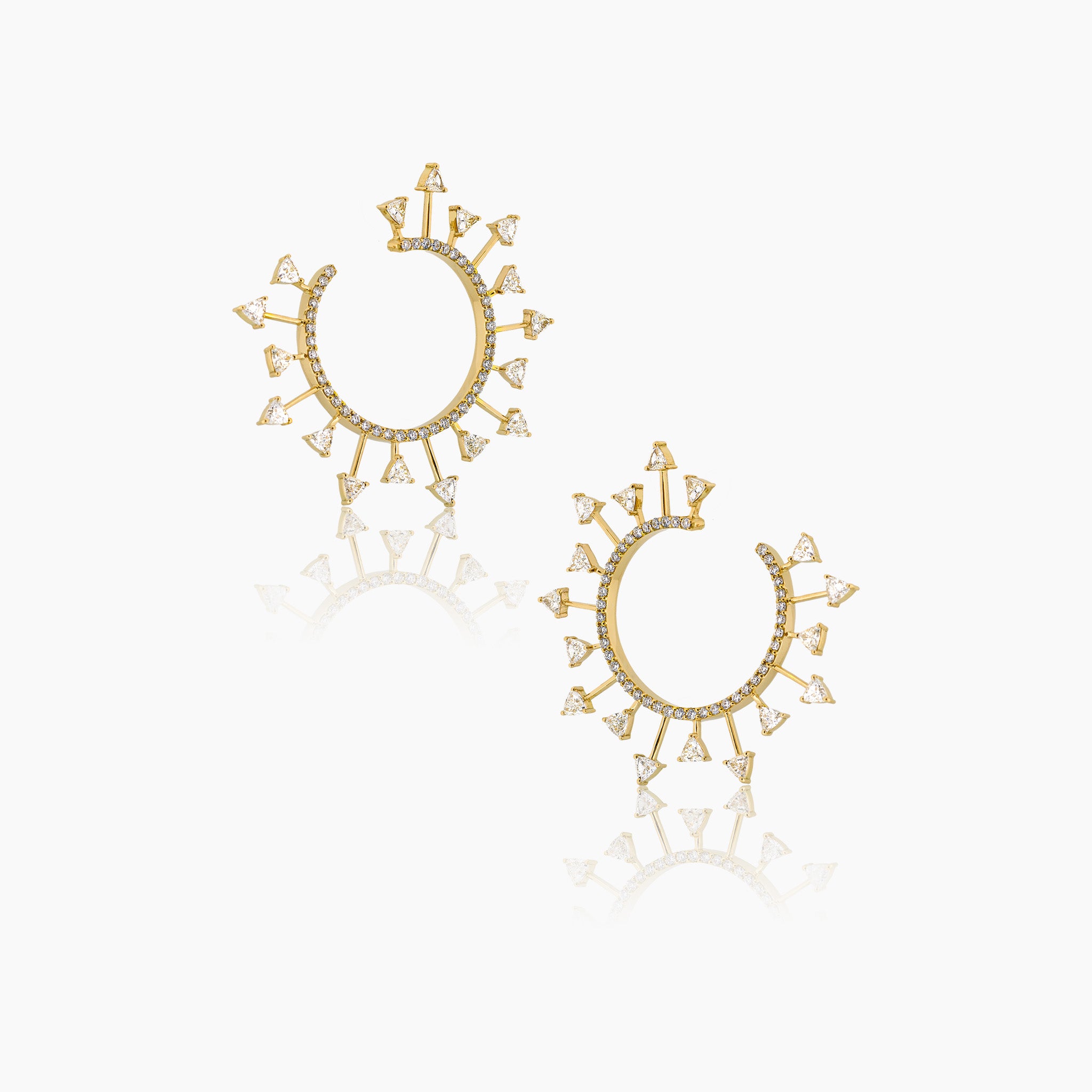Yellow gold SunScape spiral hoop earrings with trillion-cut diamonds, set against an off-white background.