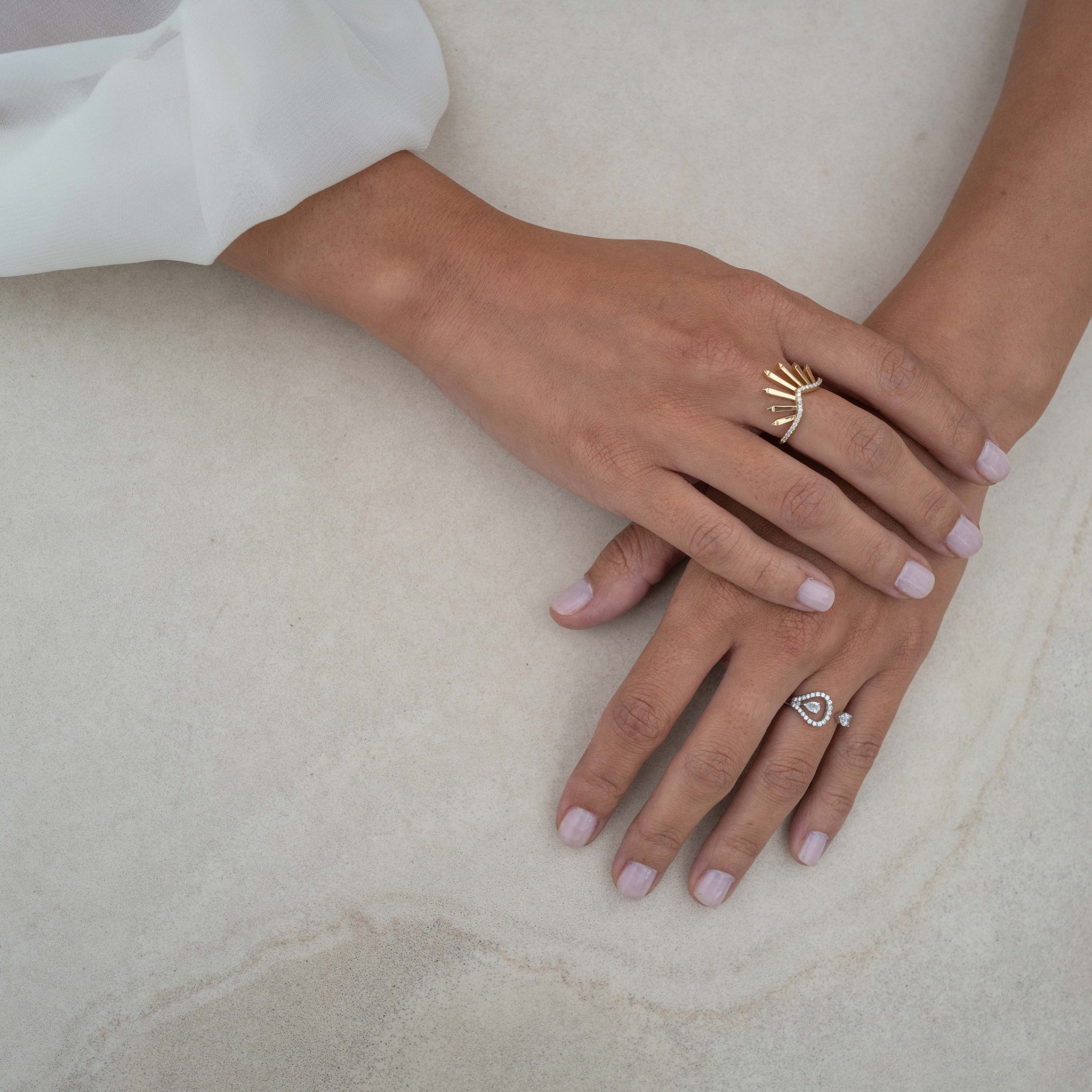 Two stunning rings in white and yellow gold  adorned with dazzling diamonds, displayed on hand model. 