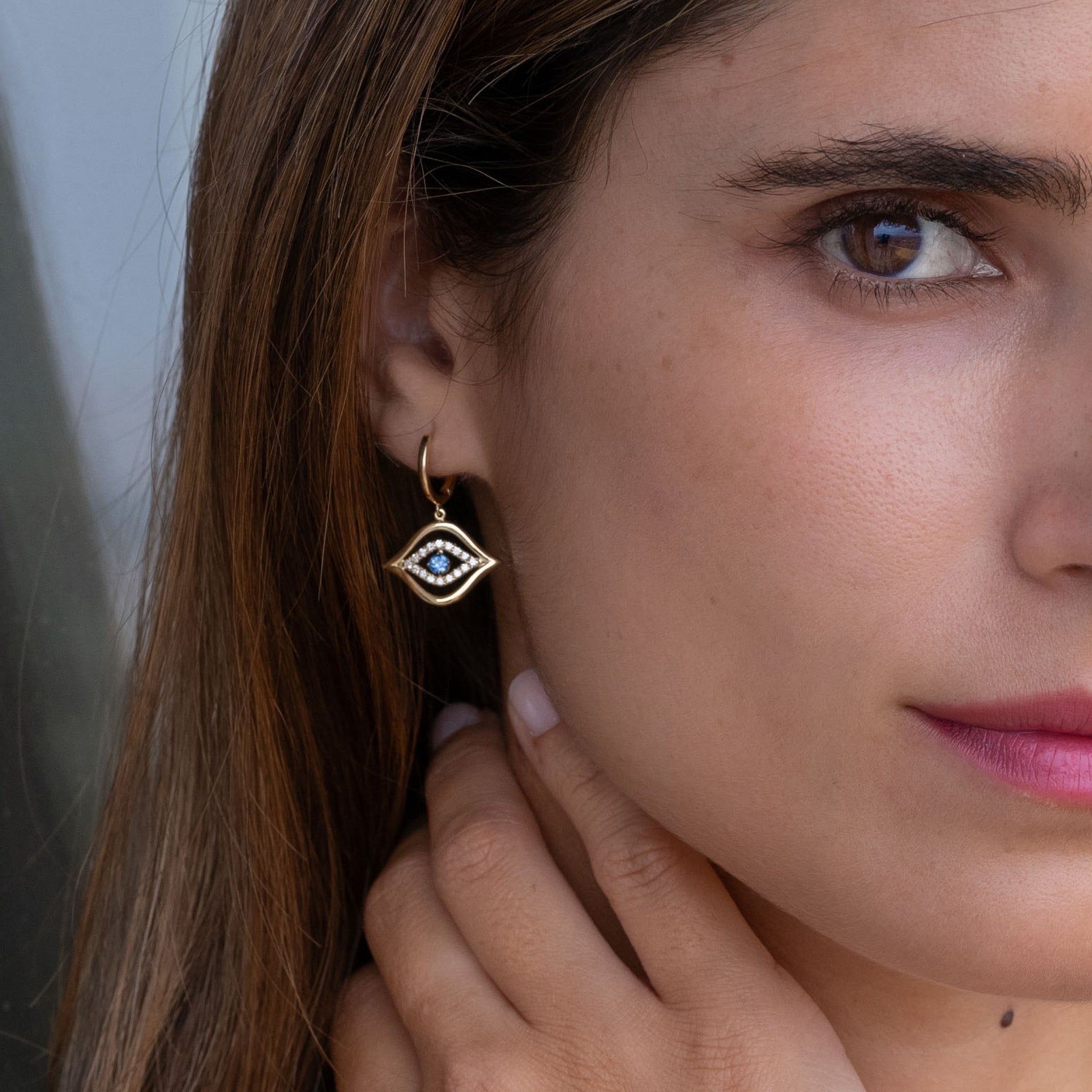 Exquisite fine jewellery featuring stunning diamond and sapphire earrings on model.