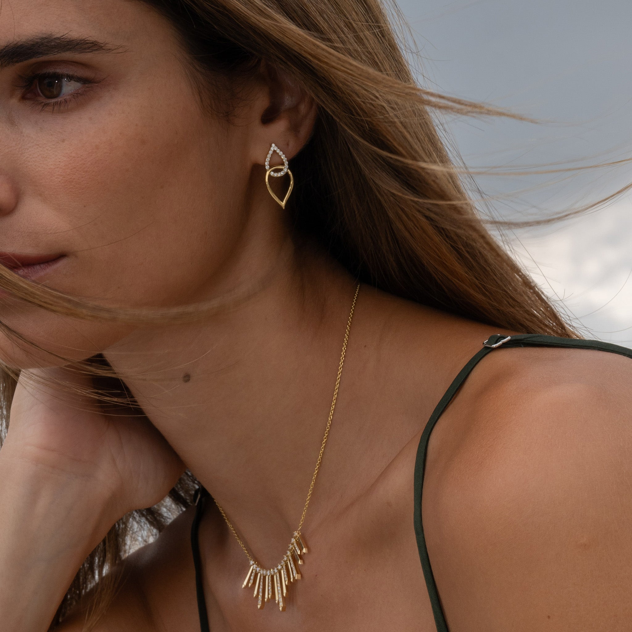 Yellow gold earrings inspired by sea knots, adorned with sparkling diamonds, showcased on model.